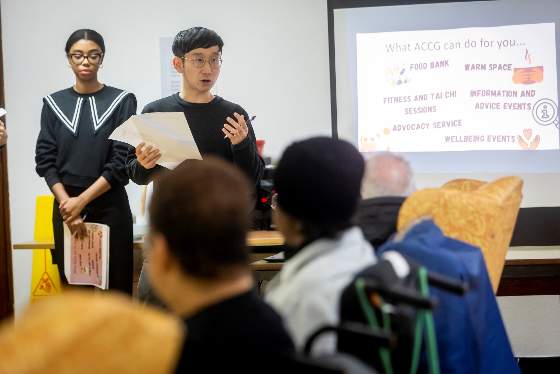 Someone teaches from the front of a room.